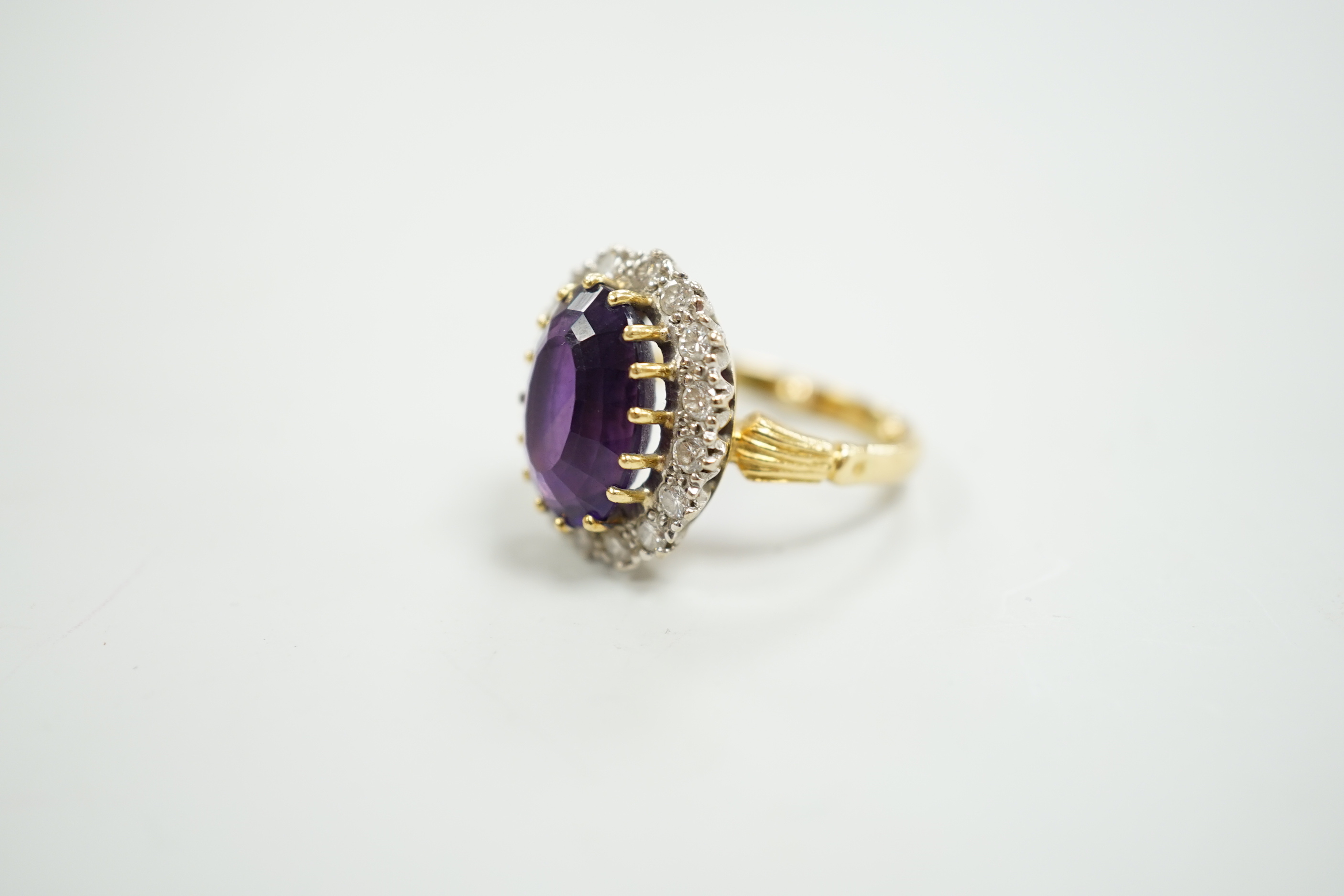 A yellow metal, amethyst and diamond set oval cluster dress ring, size K, gross weight 7.5 grams.